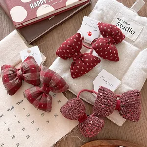 Detailed view of red plaid and sequined bow hair ties on vintage decorative background