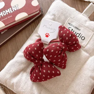 Detail of red plaid cotton bow hair ties with elastic bands on a gift card tag