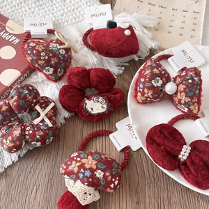 Detail of red floral velvet hair scrunchies with cute bows and festive embroidery