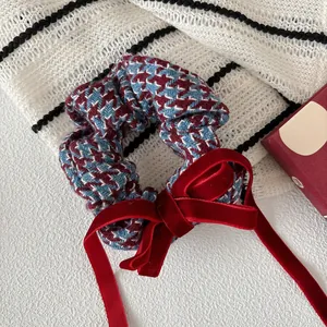 Detalle de coletero con estampado de pata de gallo azul y rojo y lazo de terciopelo