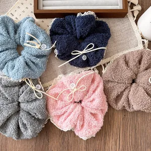 Detail of plush scrunchies in five colors with white lace trim and bow accents