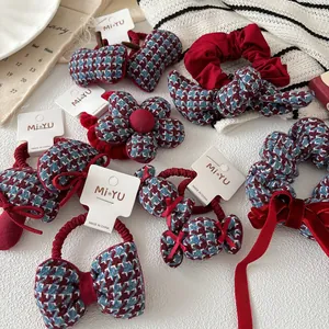 Detalle de coleteros de terciopelo con estampado de pata de gallo rojo y dijes de lazo