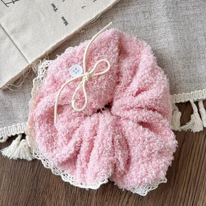 Detail of pink plush scrunchie with cream lace trim and small white button decoration