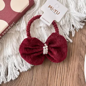 Detail of vintage burgundy corduroy hair scrunchie with delicate pearl bow embellishments