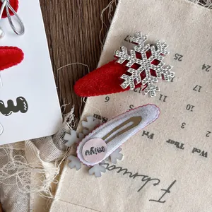 Weihnachts-Haarclip-Set aus rotem Samt mit glitzernden Strass-Schneeflocken auf Karte