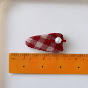 Fermaglio per capelli rosso a pois con fiocco e perla bianca per donne su fondo bianco