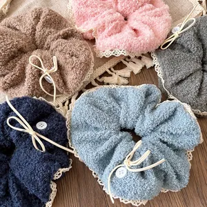 Plush oversized scrunchies with white lace edges and button bow decor in five soft colors