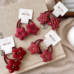 Detalle de coleteros de estrella en tela roja con varios estampados y banda elástica
