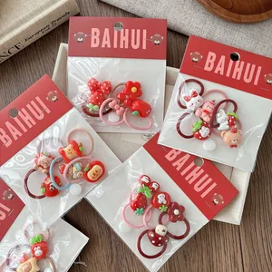 Detail of red cartoon hair ties for girls with strawberry and bunny resin charms