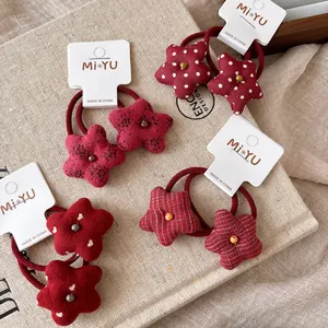 Detalle de gomas para el pelo con estrellas rojas y motivos de lunares y flores en lino
