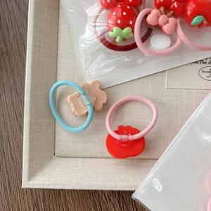 Cute red cartoon hair ties for girls featuring strawberry and bear charms in a set