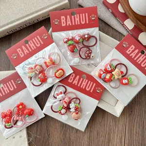 Detail of red cartoon hair ties for girls featuring cute resin animal and fruit charms