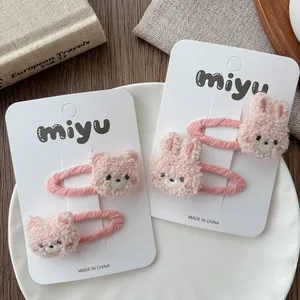 Close-up of a 4-piece set of pink plush bear and rabbit hair clips on white cards