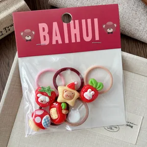 Detailed close-up of a 5-piece red cartoon hair tie set with resin animal and fruit charms