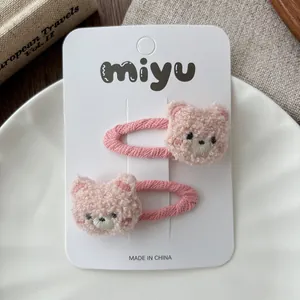 Close-up of cute pink plush bear hair clips on decorative display card and plate