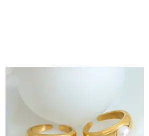 Detail van verstelbare vergulde ringen met een witte parel en gladde afwerking