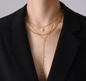Dettaglio della collana a Y dorata a più strati con perle d'acqua dolce su un blazer