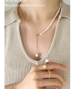 Primer plano de collar de perlas y anillos dorados usados por modelo en punto beige