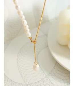 Detalle del collar en Y con perlas de agua dulce, cadena de serpiente dorada y corazón