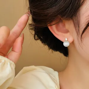 Close-up view of elegant cat eye stone stud earrings with zircon detail on ear