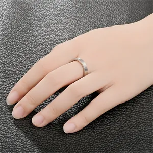 Vista dettagliata di un anello minimalista in acciaio al titanio argento opaco sulla mano