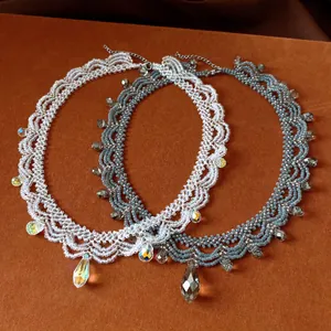 Detailed view of handmade glass beaded lace necklaces with teardrop crystal pendants