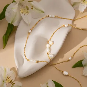 Close-up of 18K gold stainless steel necklace with elegant white baroque pearls.