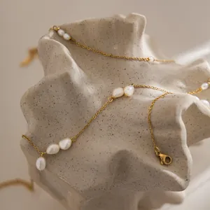 Close-up detail of a minimalist 18K gold plated stainless steel necklace with baroque pearls
