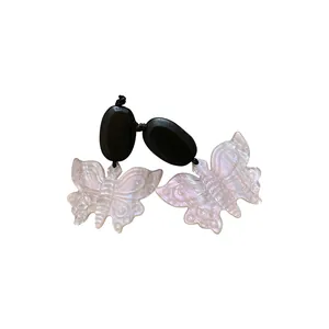 Boucles d'oreilles rétro en bois et résine irisée papillon sur fond blanc pur.