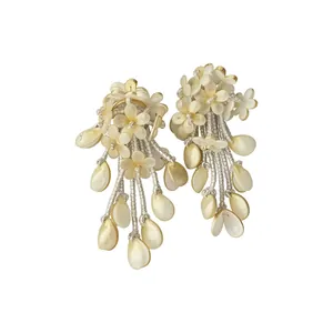 Exaggerated floral tassel earrings with cream shell petals and golden beaded fringe