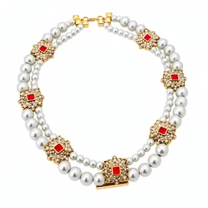 Elegant double-layered pearl necklace with vintage floral spacers and red stones.