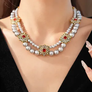 Close-up of a double-layered pearl necklace with vintage floral pendants on a model