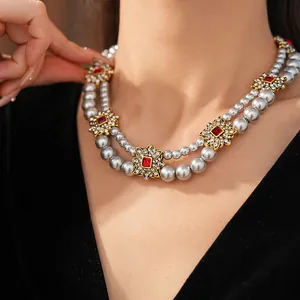 Detail of vintage double-layer pearl necklace with rhinestone flowers and red gems