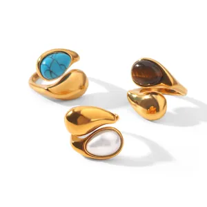 Detailed view of teardrop open rings with turquoise, tiger's eye, and pearl inlays