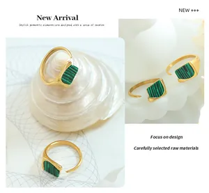 Detail of adjustable gold ring with geometric green turquoise stone on a white conch shell