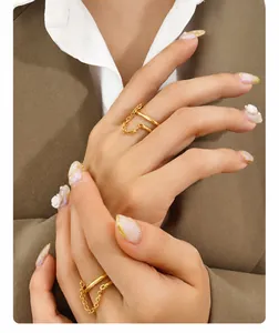 Dettaglio di un doppio anello d'oro minimalista con catena sottile su modella