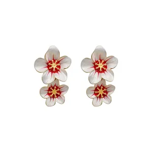 Elegant handcrafted dripping oil white flower earrings with gold and red center accents