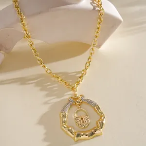 Dettaglio di una collana dorata con pendente a lucchetto irregolare con strass