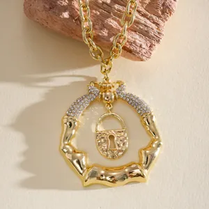 Dettaglio macro della collana anello d'oro irregolare con strass e ciondolo a lucchetto