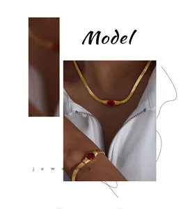 Detail von goldenem Schlangenkette-Schmuckset mit roten Edelsteinen an einem Modell