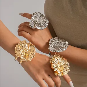 Detailed view of gold and silver metallic wrinkled flower bangle and ring jewelry set