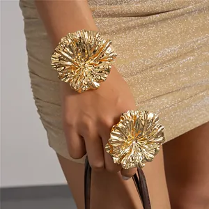 Detailed close-up shot of elegant gold crinkled flower bracelet and matching ring set