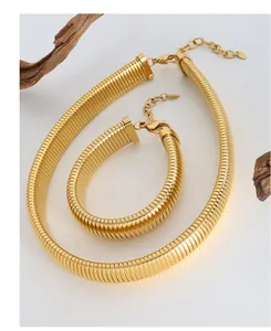 Macro view of gold textured snake chain necklace and bracelet jewelry set with lobster clasps