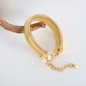 Gold-plated stainless steel omega snake chain bracelet with K18 tag on vintage wood