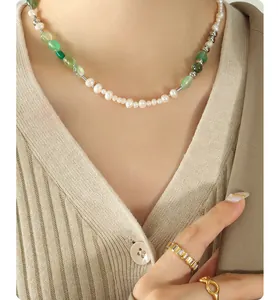 Detalle de collar de perlas de agua dulce con piedras verdes y anillos de circonitas