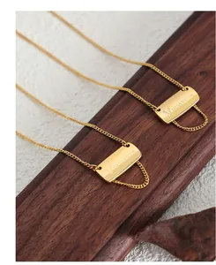 Dettaglio della collana a nappa dorata con pendenti rettangolari in finitura spazzolata