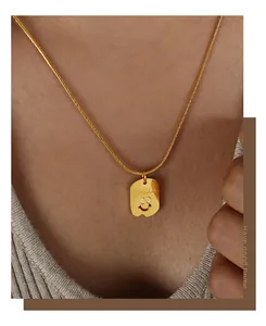 Detailansicht eines goldenen Smile-Anhängers mit Zirkonia-Augen an einer Schlangenkette
