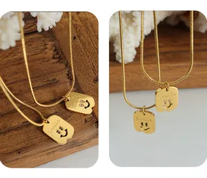 Details des goldenen Smile-Anhängers mit Zirkonia-Augen an einer feinen Schlangenkette