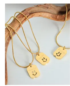 Detailansicht der goldenen Schlangenkette mit gravierten Smile-Rechteck-Anhängern