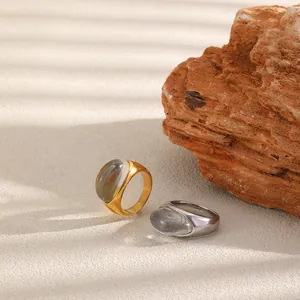Anillo de acero inoxidable bañado en oro 18K con resina ovalada sobre una superficie rugosa